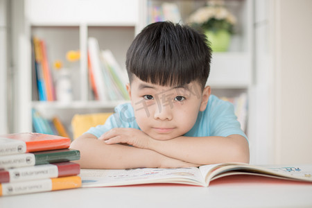 趴在阳台的小孩摄影照片_趴在书上的小男孩