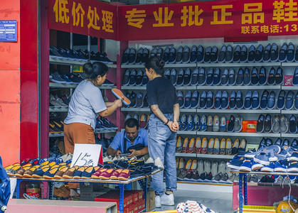 街头人文摄影摄影照片_正在卖鞋的人摄影图