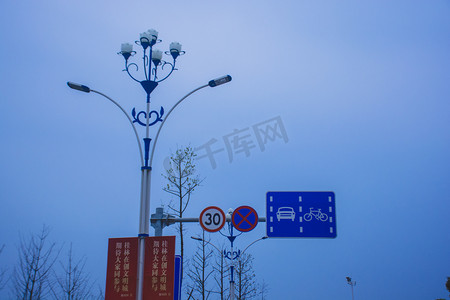 天空下的马路路灯指示牌摄影图