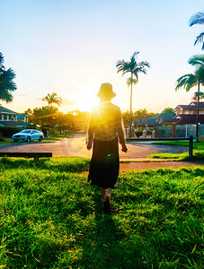 民宿活动海报摄影照片_澳大利亚民宿区夕阳下女生的背影