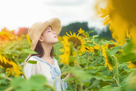 女王节女生节摄影照片_少女闻着向日葵的花香