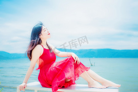 写真摄影照片_海边红裙美女仰望天空写真