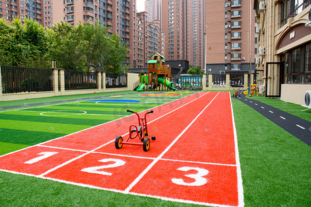 幼儿园食谱摄影照片_幼儿园操场跑道上的三轮童车摄影图