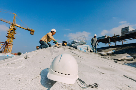 五一劳动节屋顶上施工的建筑工人摄影图