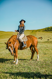 牛仔美女摄影照片_在草原上骑马的美女