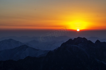 山峰照片摄影照片_霞光山峰和太阳的照片