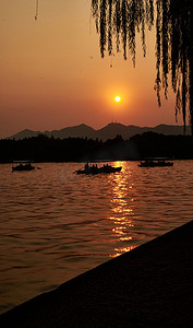 黄昏美景杭州西湖湖面金色的太阳摄影图