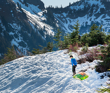 人物冷摄影照片_雪山山谷中独自玩雪的小朋友