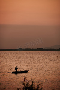 落日黄昏湖边水面渔船 摄影图
