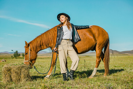 在草原上牵着马美女摄影图