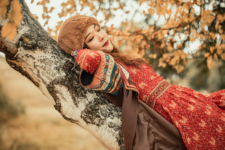 秋天躺在白桦树下的美女