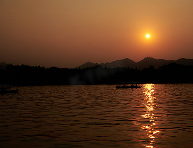 落日美景杭州西湖湖面金色的太阳摄影图