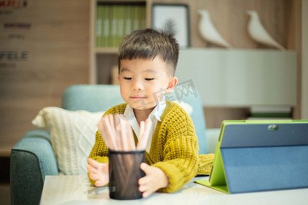 小男孩拿摄影照片_手拿笔筒玩耍的小男孩