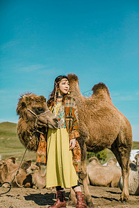 内蒙古草原上和骆驼合影的姑娘摄影图