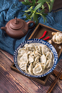 花边水饺摄影照片_美食木桌水饺大蒜茶壶摄影图