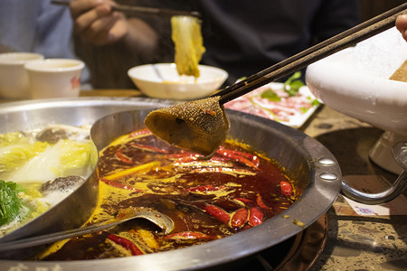 复活节聚餐摄影照片_火锅店朋友聚餐夹毛肚餐饮美食图