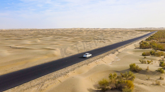 汽车沙漠摄影照片_沙漠公路里飞驰的汽车