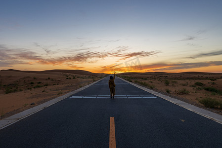 夕阳落日人在公路摄影图