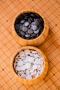 围棋摄影照片_围棋棋盘上的棋罐装满黑白棋子