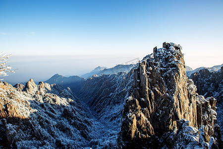 冬季岩石白雪和山峰摄影图