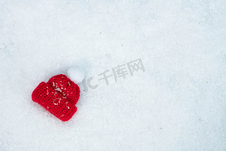 圣诞雪雪摄影照片_雪地上的红色圣诞帽
