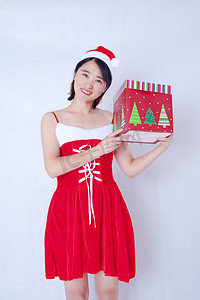 室内白背景抱着礼品盒的红色圣诞人像摄影图