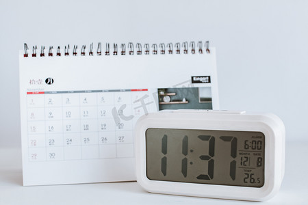 时间管理摄影照片_白色桌子上的台历和计时钟表