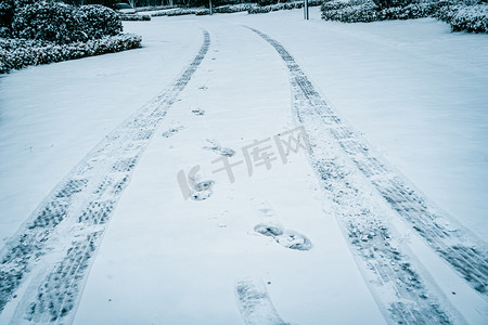 小雪大雪节气摄影照片_大雪路面上的车印脚印