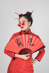 春节扇子扇子摄影照片_穿旗袍拿扇子的人物