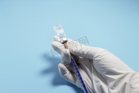 疫苗预防接种摄影照片_蓝色背景前的疫苗