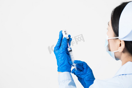 疫情疫苗摄影照片_用注射器吸取疫苗药水的护士