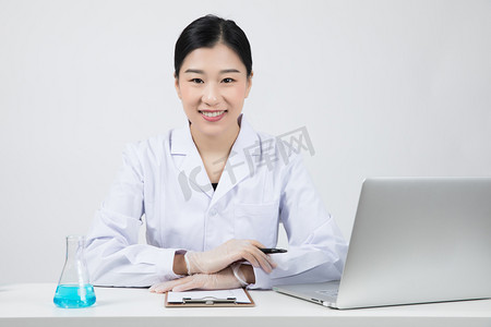 记录中国摄影照片_在办公桌上做实验记录的女医生