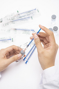 新冠抗原试剂盒主图摄影照片_医生在用针管吸取疫苗实拍图