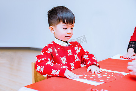 过年小孩摄影照片_做剪纸的小男孩