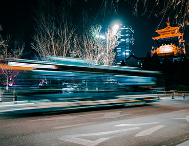 城市霓虹摄影照片_冬天夜景生活马路上行驶经过的车