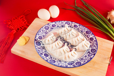 喜庆小报摄影照片_新春节日喜庆美食过年包饺子摄影图配图