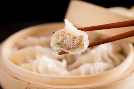 新年除夕年夜饭摄影照片_饺子剖面夹起筷子蒸饺年夜饭喜庆摄影图配图