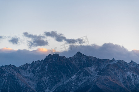 雪山日落摄影照片_觉巴山夕阳日落山峰室外摄影摄影图配图