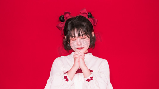 红色摄影照片_春节拜年新年过年女孩室内祈祷许愿摄影图配图