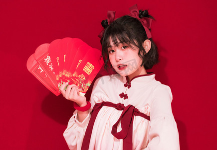 新年签喜庆海报摄影照片_拜年新年过年春节拜年女孩室内发红包摄影图配图
