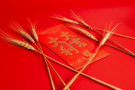 红包拍摄影照片_春节新年麦穗下的红包室内棚拍摄影图配图