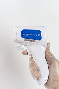 家电体温计摄影照片_医疗安全疫情期间拿额温枪的手体温测量摄影图配图