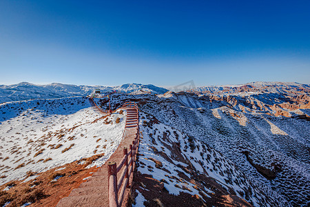 甘肃张掖晴天平山湖大峡谷雪后栈道摄影图配图