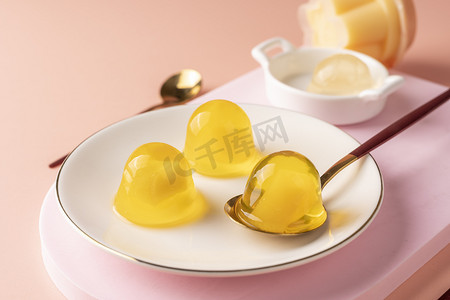 勺子黄色摄影照片_果冻白天果冻桌子盘子摄影图配图