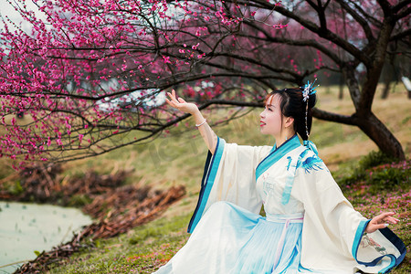 花摄影照片_古风春天汉服女子户外赏梅摄影图配图