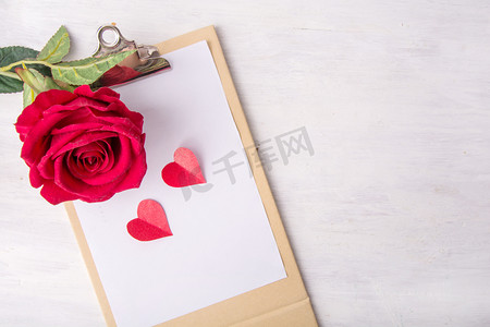 玫瑰信纸摄影照片_情人节白天玫瑰花木桌子上摆放摄影图配图