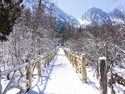 雪山雪地摄影照片_自然风景冬天雪山里的桥风光高清摄影图配图