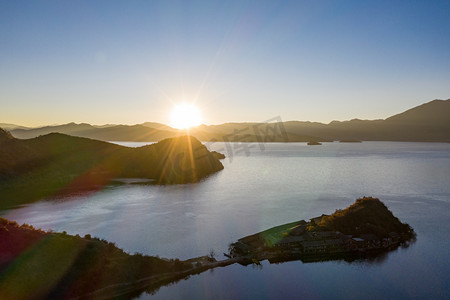 泸沽湖摄影照片_泸沽湖日出星芒日出湖面太阳室外摄影摄影图配图