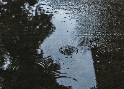 春天雨水摄影照片_雨水下雨水洼路面下雨摄影图配图