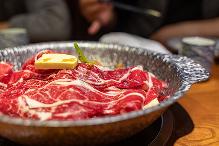 日料摄影照片_美食肥牛寿喜锅日料店火锅摄影图配图